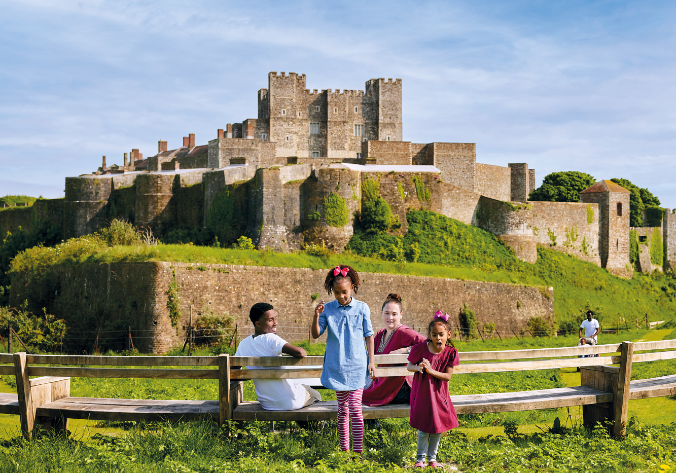 Children are standing in front of a large castle
