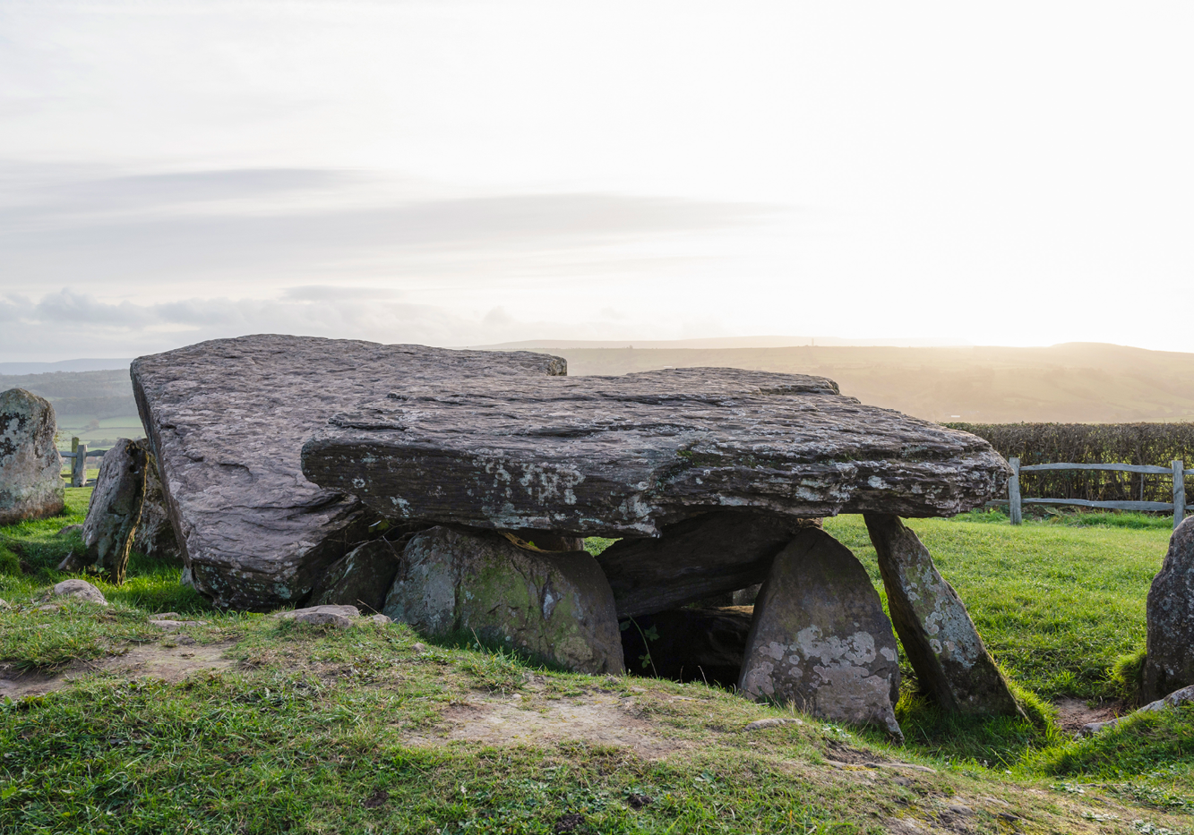 A Neolithic stone tomb - large stones are arranged in a rectangular shape with a larger stone on top as a roof and another standing stone to the side 